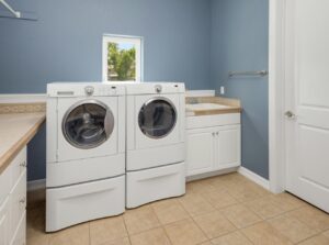 Laundry room with side-by-side washer and dryer against blue wall
