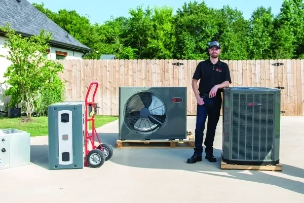 Colonial technician standing in the driveway of a house with new air conditioning systems to be installed